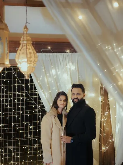 Another angle of the fairy light setup, showing the couple ready for a celebratory toast. The warm lights create a wonderfully romantic mood.