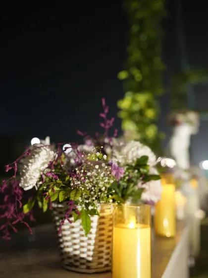 Attention to detail is what defines our decor. This close-up shows a floral arrangement in a woven basket paired with flameless candles, creating a safe yet warm and inviting atmosphere.