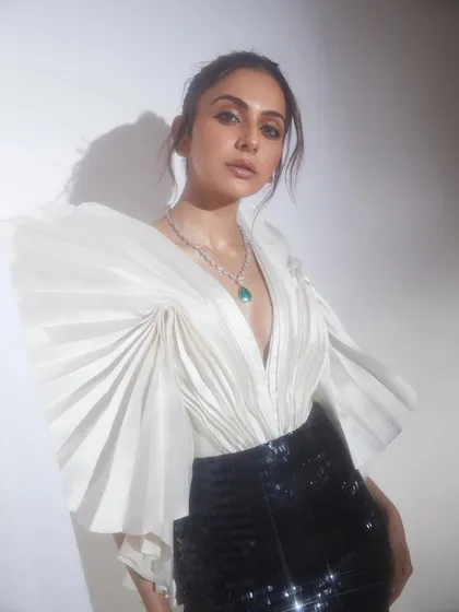 This look is all about sharp, structural elegance. The combination of a dramatically pleated white top and a sleek sequin skirt creates a powerful, high-fashion statement, perfect for awards nights or formal corporate events.