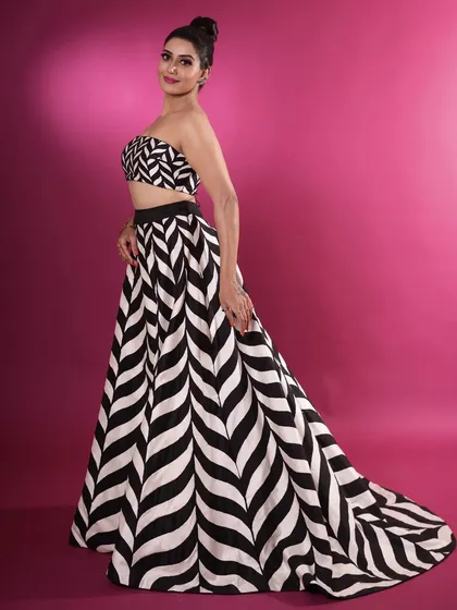 For a bold, graphic statement, I designed this black and white chevron print lehenga. The set includes a tube top and a gored skirt with an extended train, offering a sleek and modern alternative to traditional occasion wear.