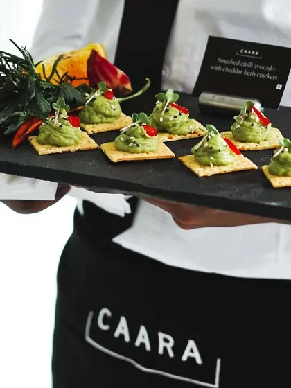 Our professional staff serving smashed chili avocado on cheddar herb crackers. We ensure impeccable service, passing around delicious canapés so you can focus on enjoying your event and your guests.