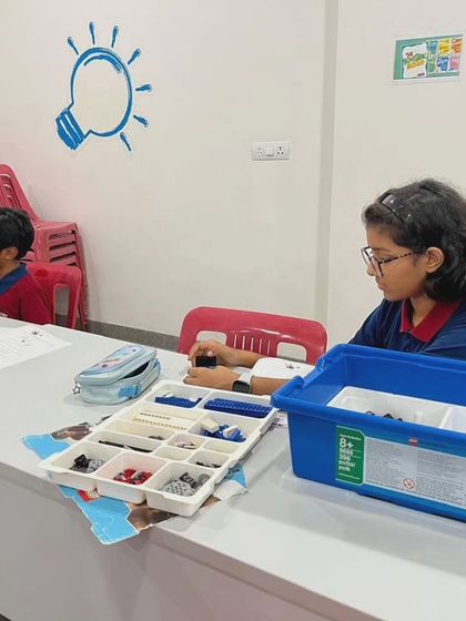 A student at our Vidyashilp Academy after-school program concentrates on sorting her LEGO pieces, an important step in organized building.