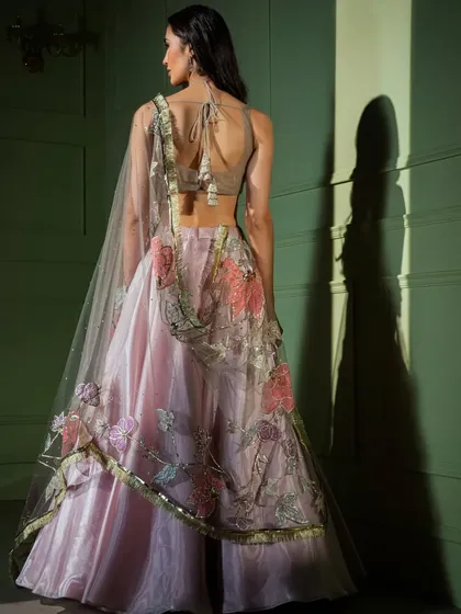 The back view of the pastel pink floral lehenga, showing the sheer back of the blouse and the delicate embroidery on the dupatta.