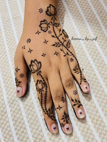 A slightly different angle of the delicate lotus and beaded chain design, showing its elegant placement on the hand.