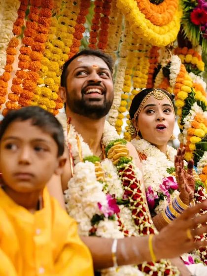 A candid shot capturing the couple's surprised and happy expressions during a ritual at their Tamil wedding.
