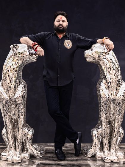 A powerful environmental portrait. Posing with these stunning panther sculptures adds a unique and bold statement, perfectly reflecting the client's personal brand.