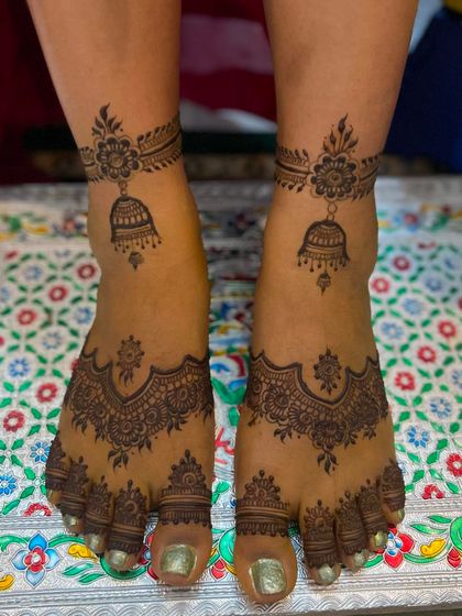 A delicate and beautiful foot design featuring hanging jhumka (bell) motifs, creating a jewelry-like effect.