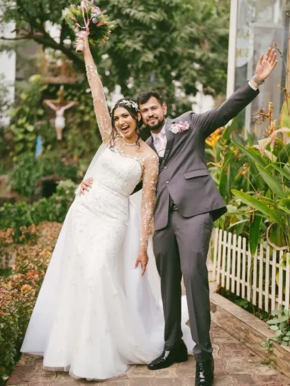 The triumphant exit from the church, arms raised in celebration. This photo captures the pure, uncontainable joy of a newly married couple, ready to start their life together.