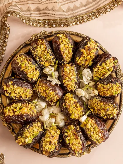 A platter of my Caramel Almond Praline stuffed Moroccan dates, garnished with pistachios. These are a timeless and elegant treat for any festive occasion.