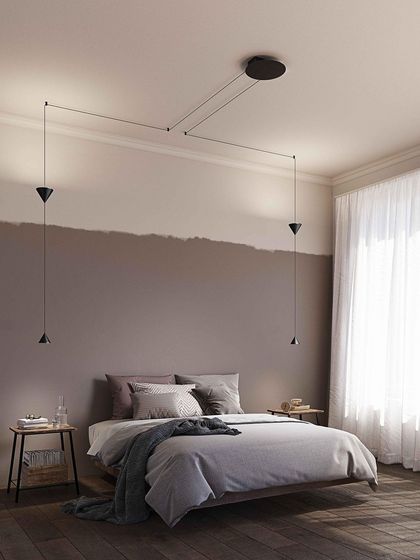 The Filomena system used as bedside lighting, with the cords cleverly routed from a central ceiling rose to create a custom, symmetrical installation.