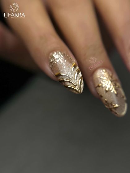 An elegant leaf-inspired 3D gold design. The raised metallic pattern sits on a glittery nude base, creating a beautiful contrast in texture and shine.