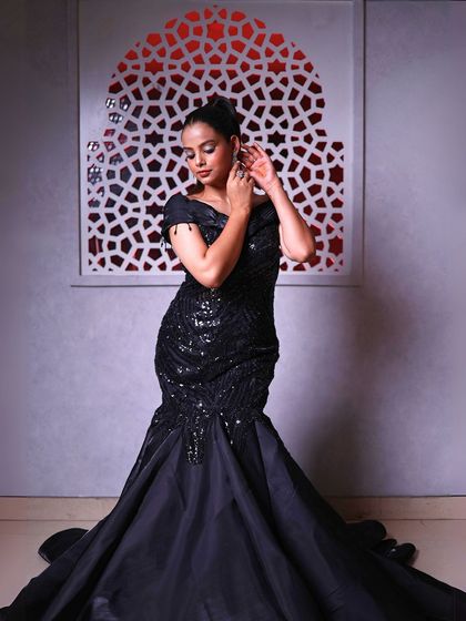 A full-length shot showing the dramatic trail of the black gown.