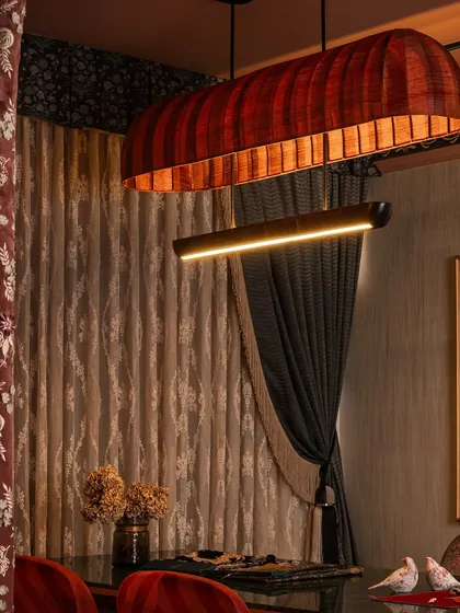 This custom client interaction table is clad in alternating panels of rich red and teal fabric, topped with Udaipur green marble. It's a bold mix that reflects the energy and confidence this space needed to hold, showing how we let fabrics speak in full voice.