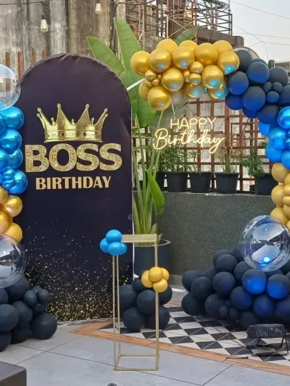 A bold "Boss Birthday" theme for an outdoor or terrace party. The decoration uses a striking combination of black, blue, and gold balloons, a custom backdrop, and a neon sign, creating a powerful and fun statement.