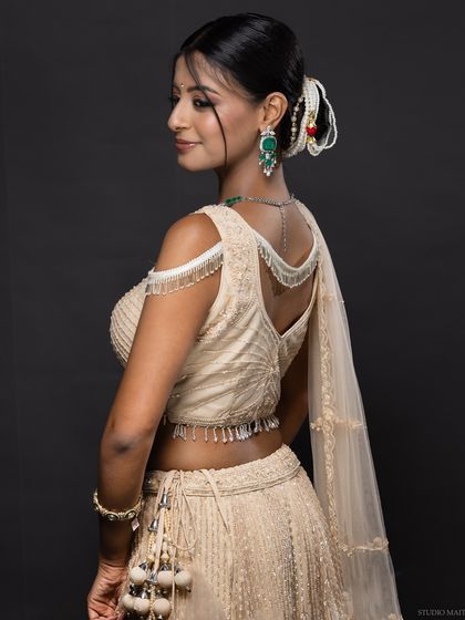A shot showing the back detail of the lehenga blouse and the model's hairstyle.