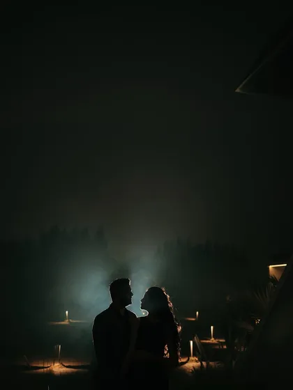A stunning silhouette of the couple against a mysterious, foggy backdrop lit by candles. This highly atmospheric and dramatic shot is perfect for a save-the-date announcement.