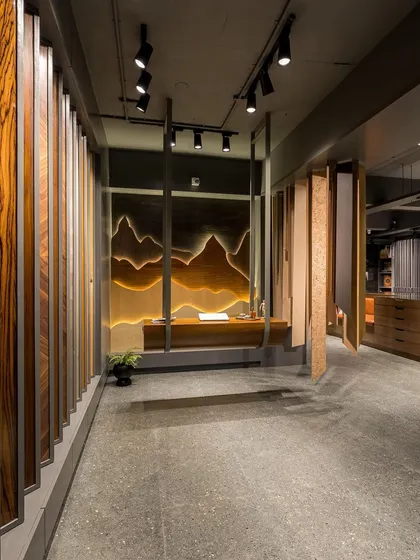 A wide shot of the showroom's main corridor, flanked by a wall of veneer samples and the suspended art installation.
