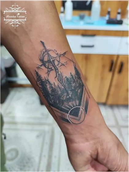 Here is the final result of a complex cover-up on a forearm. We designed this piece featuring a forest scene and a geometric sword element to completely hide the old tattoo underneath. The result is a clean, sharp, and meaningful piece of black and grey tattoo art.