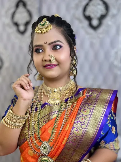 A close-up of a vibrant Nauvari bridal look, showcasing colorful eye makeup and traditional jewelry.