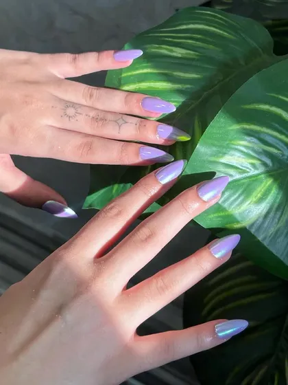 Another look at these mesmerizing lavender chrome nails. The sharp almond shape combined with the metallic shine creates a truly eye-catching effect.
