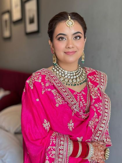 A smiling shot, showing the complete look with her stunning jewelry and traditional chooda.