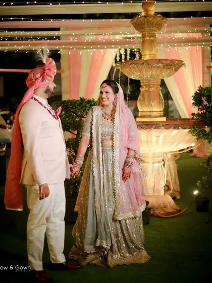 A wider shot of the couple in their wedding attire, showcasing the beautiful venue and decor. This photo captures not just the couple, but the overall ambiance of their special day.