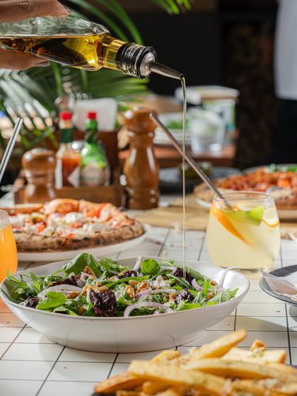 A beautifully set table with pizza, salad, fries, and drinks, ready to make a Monday feel like a weekend.