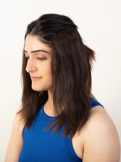 A before shot showing the model's natural hair, used to contrast with the after shot to highlight the product's volumizing effect.