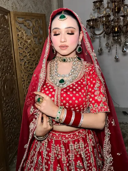 A soft, elegant pose showing the shimmer on the eyes and the intricate details of the emerald and polki jewelry.