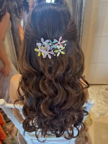 A close-up of the half-updo with the pretty, pastel-colored floral hair clip.