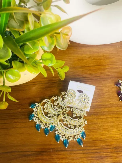 The same stunning tiered chandbali design, this time with teal-colored beads. This is a great option if you want to add a unique jewel tone to your ethnic wear.
