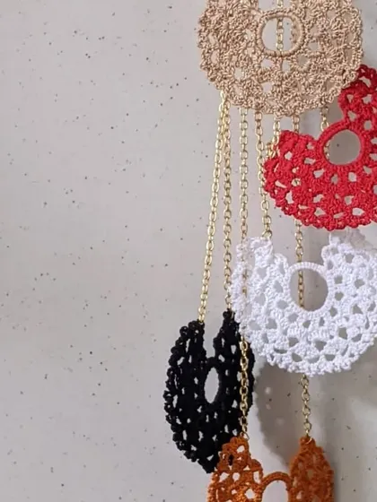 Our crochet lace pendants come in a color for every mood. These delicate, half-moon shaped necklaces are made with intricate thread work and hung on a simple gold-tone chain.