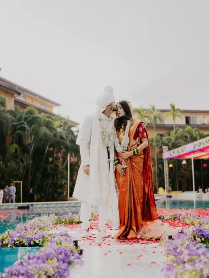 A romantic poolside portrait of the couple. The bride's elegant saree and the groom's coordinated white sherwani create a picture of modern love.