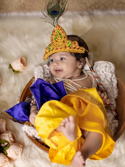 This is a duplicate of image 7. Even the tiniest newborns can join the celebration. This little one is comfortably nestled in a basket, dressed as baby Krishna, for a safe and adorable newborn photoshoot.