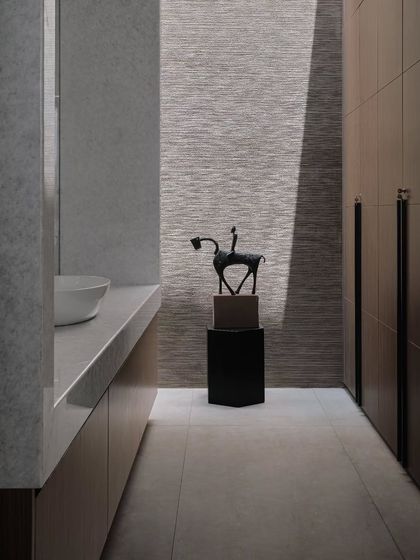 This bathroom features a unique textured wallpaper and a sculptural Dokra art piece. The design shows our ability to create sophisticated spaces with a strong sense of place and artistry.