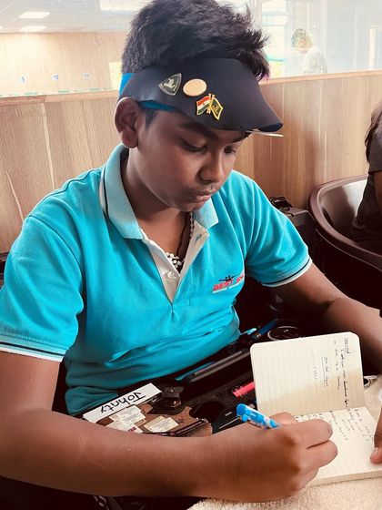 A shooter's diary is a critical tool for success. Here, one of our young athletes meticulously tracks his performance, notes coaching feedback, and sets goals for improvement.