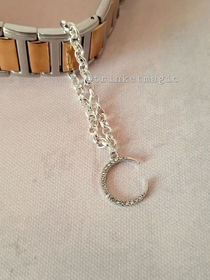 For a touch of celestial magic, this silver crescent moon watch charm is a beautiful and elegant choice. The sparkling crystals add extra shine.