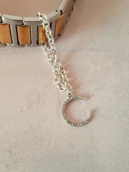 For a touch of celestial magic, this silver crescent moon watch charm is a beautiful and elegant choice. The sparkling crystals add extra shine.