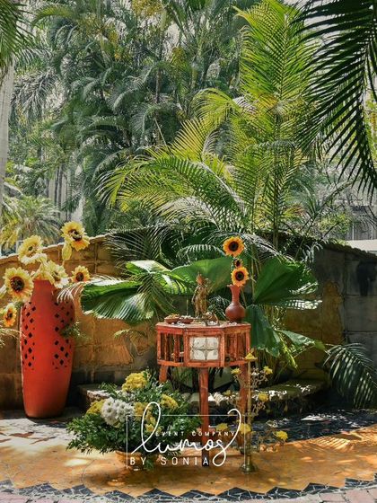 A vibrant sunflower arrangement in a terracotta pot, part of a cheerful and sunny Haldi celebration.