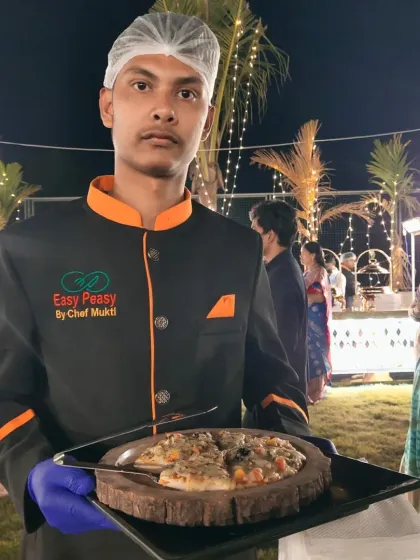 Freshly baked pizza served with a smile at an outdoor celebration. Our live pizza station is perfect for adding a fun, casual touch that guests of all ages enjoy, from pre-wedding parties to birthday celebrations.