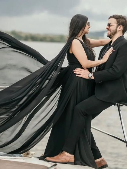 A chic and modern pre-wedding shoot on a yacht featuring our black trail gown. The flowing train adds a touch of elegance and movement to the sophisticated all-black theme.