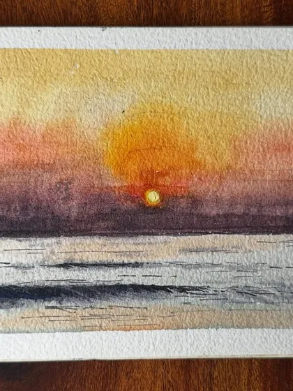 A close-up of my watercolour sunset painting, showing the granulation of the pigments and the texture of the handmade paper.