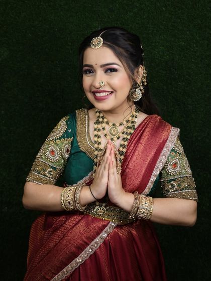 A respectful and traditional pose that beautifully showcases the entire ensemble, from the outfit to the jewellery.
