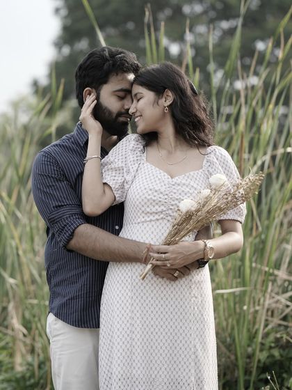 An intimate and romantic close-up of a couple in a field of tall grass, capturing a tender moment.