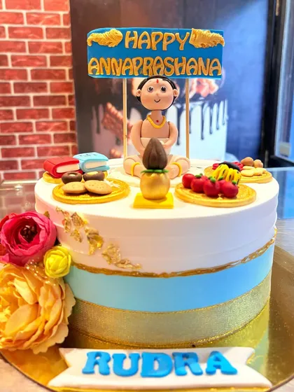 The full Annaprashan cake, decorated with fresh flowers and gold accents to celebrate this important milestone.