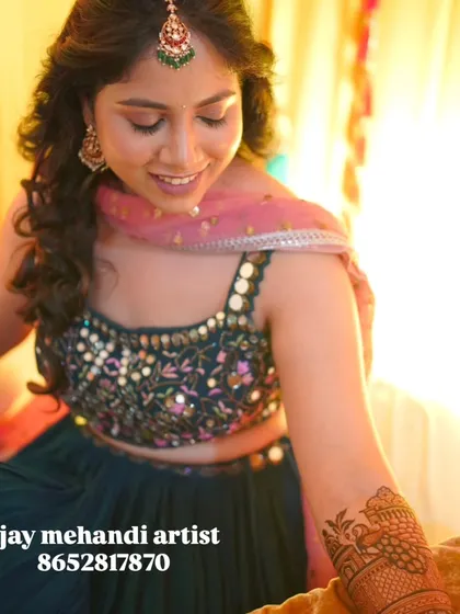 A candid photo of a client during her mehndi ceremony, with a beautiful smile.