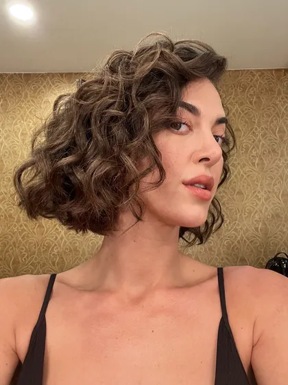 Hair artistry is a key part of my service. Here, I styled a chic, curly bob for a Realme ad shoot, defining the curls to create texture and volume for a fun, modern look that holds up on set.