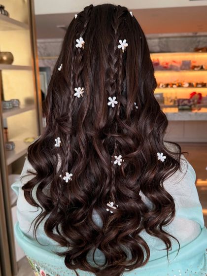 A detailed shot of the small braids and floral clips scattered through the loose waves.