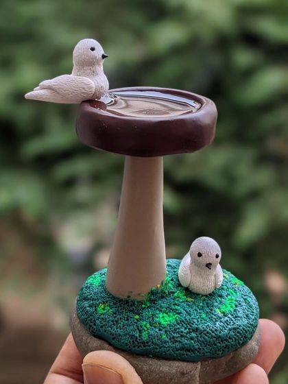 Splish, splash, birds at play! This miniature bird bath, with two little birds, adds a touch of whimsy to your garden or home decor.
