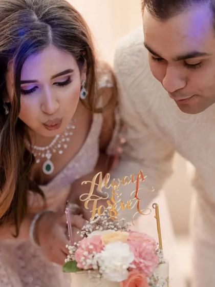 A close up of the couple blowing out the candles on their engagement cake, a moment of shared celebration.